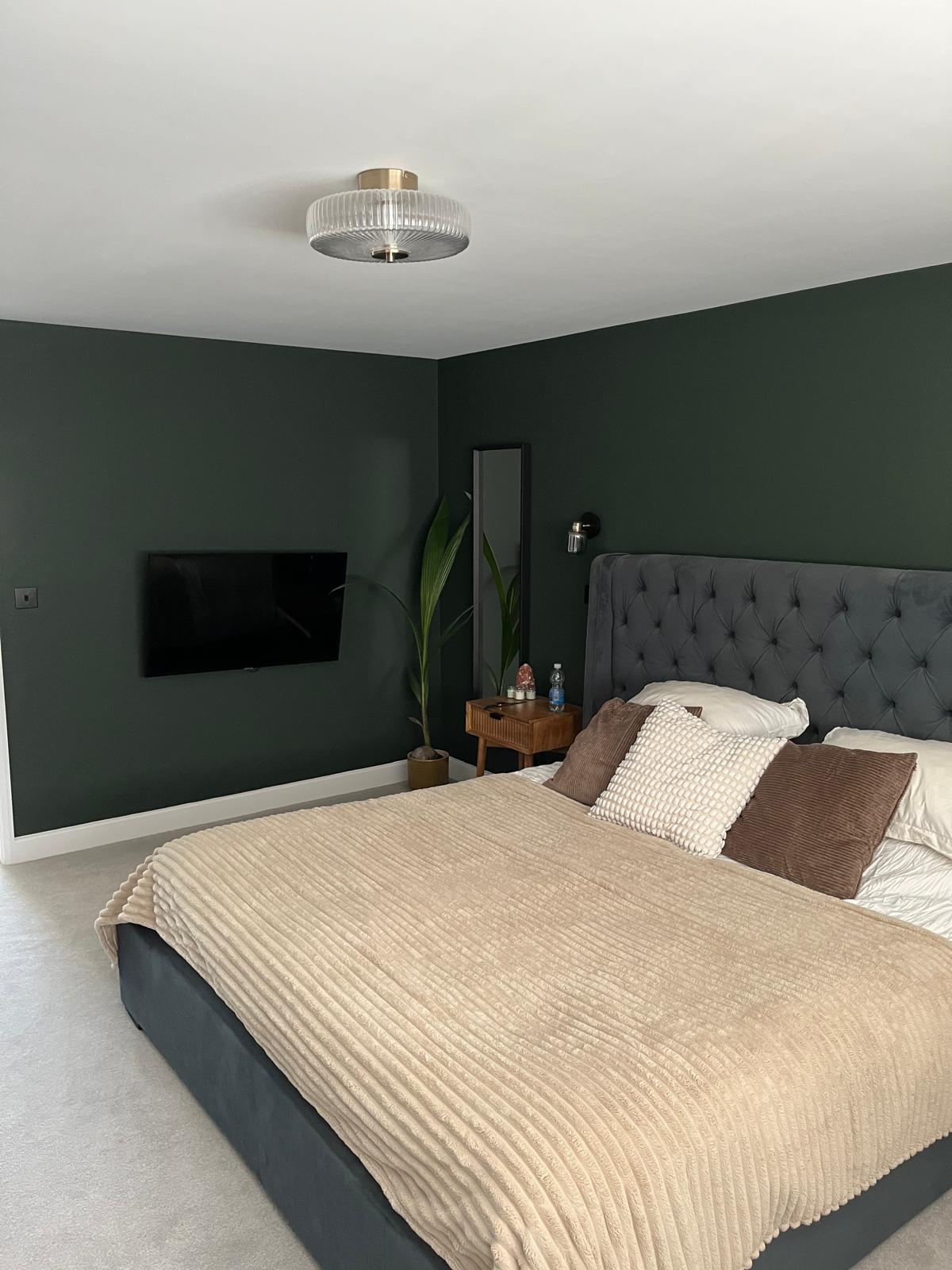 Green bedroom with wall-mounted TV